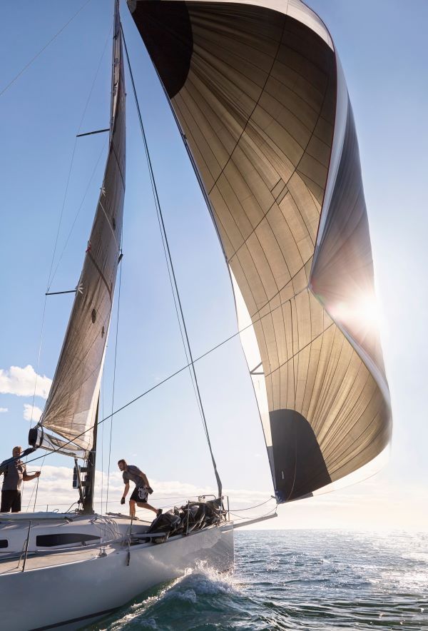 Wind pulling sail on sailboat on sunny ocean